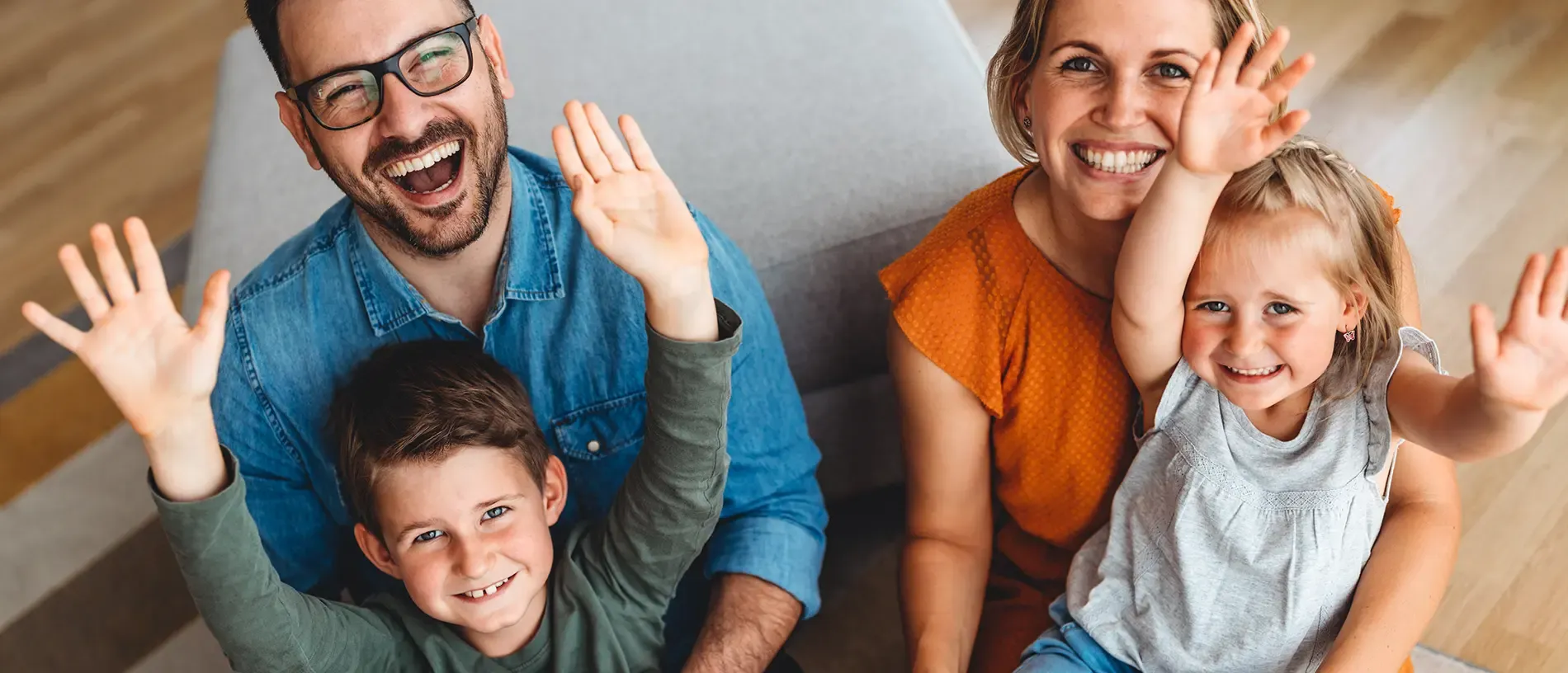 Smiling family with arms extended towards camera
